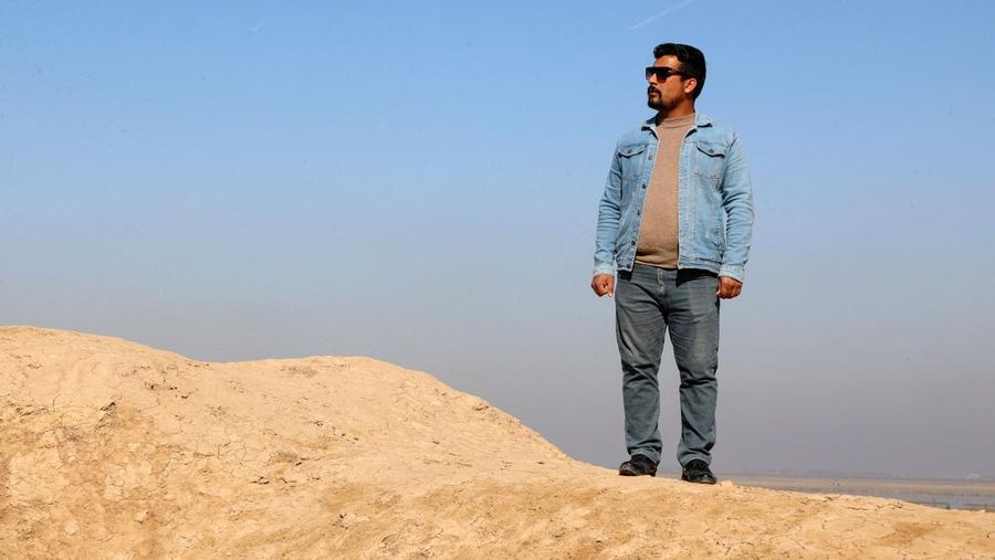 Gambar udara ini menunjukkan arkeolog Irak Baqer Azab Wali berdiri di parit yang baru digali di situs negara kota kuno Lagash, di distrik al-Shatra Irak di provinsi Dhi Qar selatan pada 11 Februari 2023. - Italia dan AS arkeolog yang melakukan penggalian di Lagash di Irak selatan telah menemukan sebuah 