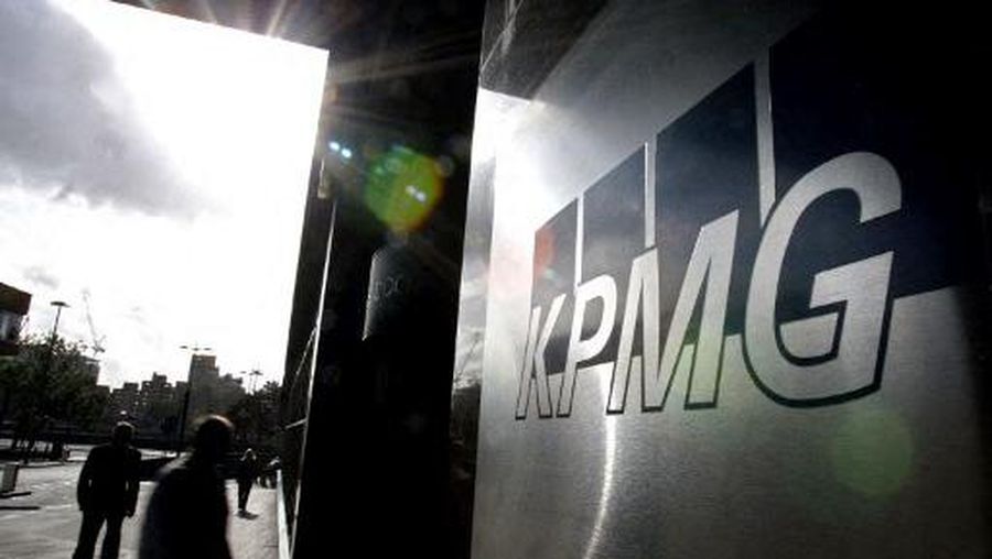 Employees of KPMG in London walk in and out of the building 25 October 2005. Staff at KPMG are in store for bumper Christmas bonuses as the firm will pay its 8,950 UK staff a total bonus of 59m compared with 35m last year.  AFP PHOTO/LEON NEAL (Photo by LEON NEAL / AFP)