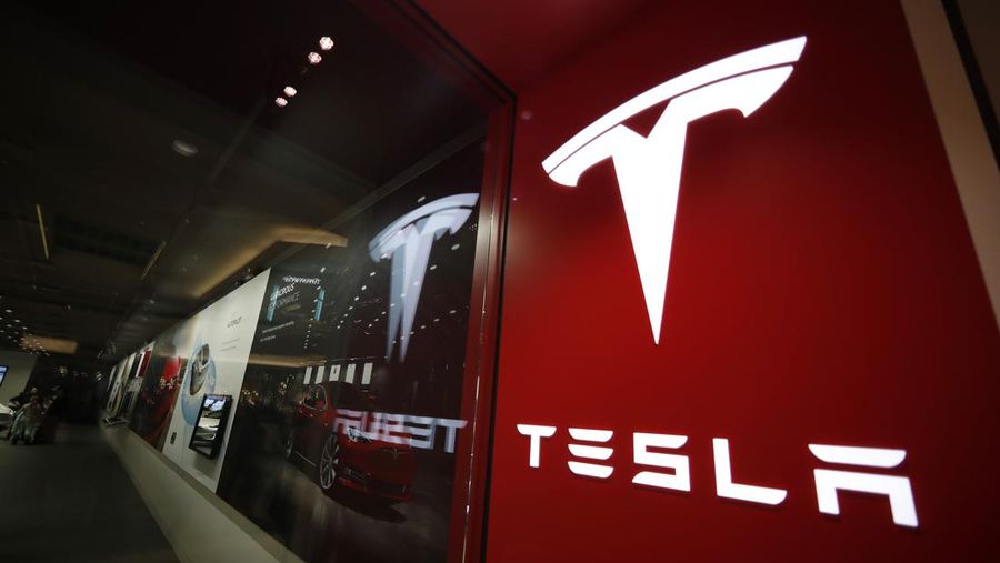 FILE - A sign bearing the company logo outside a Tesla store in Cherry Creek Mall in Denver is seen here on Feb. 9, 2019. Tesla is recalling nearly 363,000 vehicles with its “Full Self-Driving” system to fix problems with the way it behaves around intersections and following posted speed limits, the National Highway Traffic Safety Administration announced Thursday, Feb. 16, 2023. (AP Photo/David Zalubowski, File)