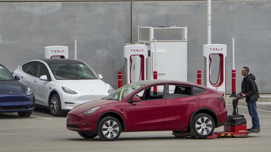 A worker moves a Tesla car at Tesla's Giga Texas automotive manufacturing facility in Austin, Texas, on Thursday Feb. 16, 2023. U.S. safety regulators have pressured Tesla into recalling nearly 363,000 vehicles with its “Full Self-Driving” system because it misbehaves around intersections and doesn't always follow speed limits. (Jay Janner/Austin American-Statesman via AP)