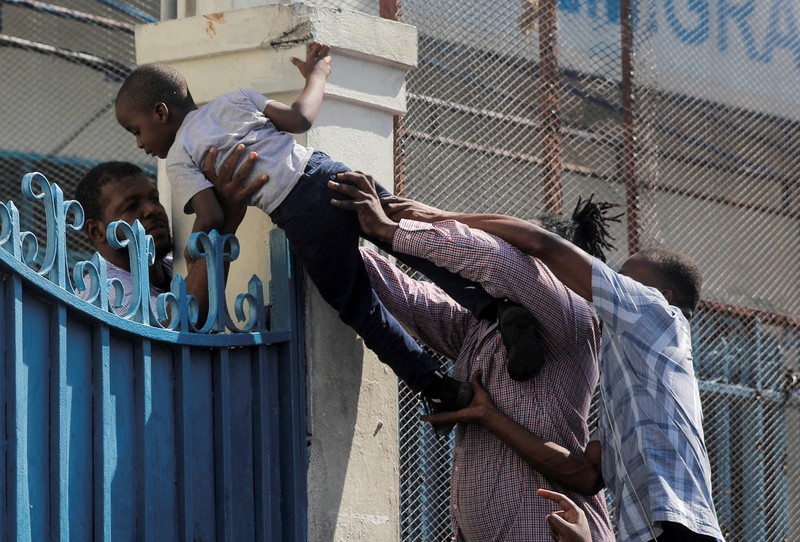 People try to force their way in to apply for a passport at an immigration office, in Port-au-Prince, Haiti February 17, 2023. REUTERS/Ralph Tedy Erol