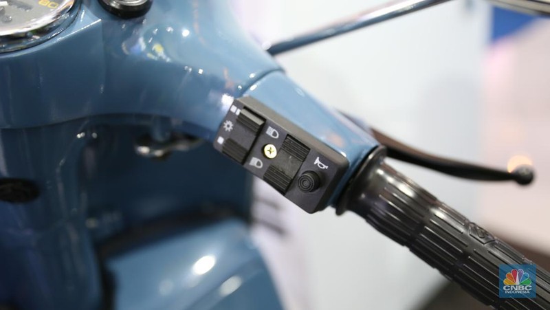 Pengunjung melihat motor lawas yang di konversi menjadi motor listrik pada booth PLN dalam ajang pameran otomotif Indonesia International Motor Show (IIMS) 2023 pada Sabtu (18/2/2023). (CNBC Indonesia/Tias Budiarto)