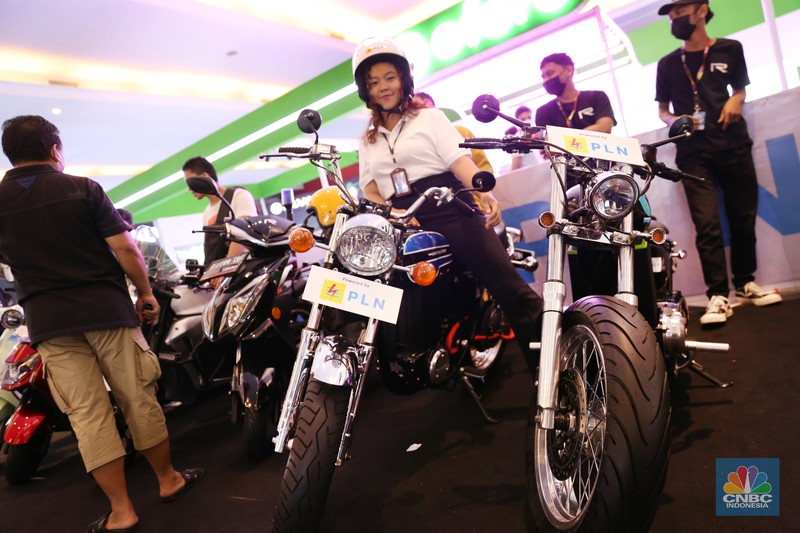 Pengunjung melihat motor lawas yang di konversi menjadi motor listrik pada booth PLN dalam ajang pameran otomotif Indonesia International Motor Show (IIMS) 2023 pada Sabtu (18/2/2023). (CNBC Indonesia/Tias Budiarto)