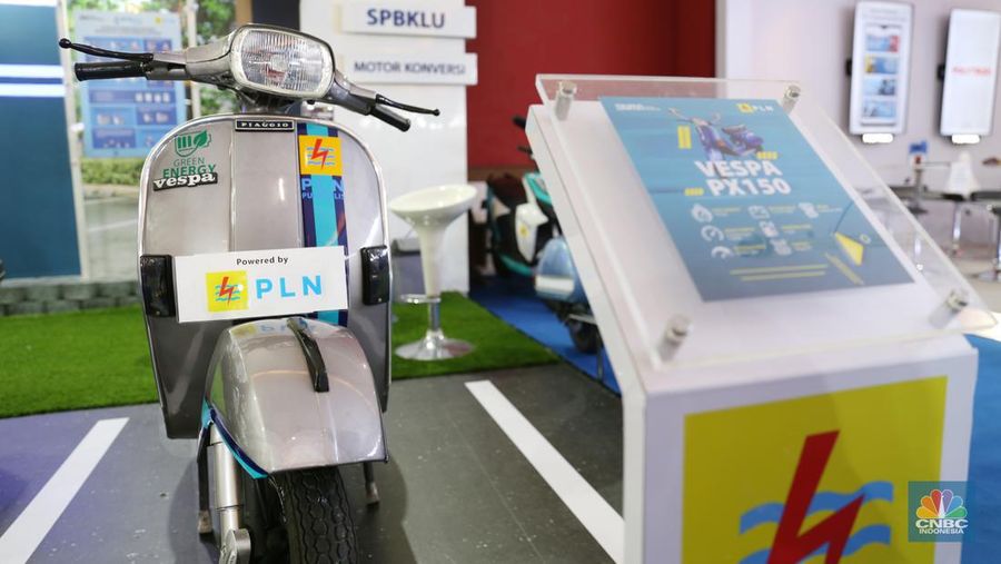 Pengunjung melihat motor lawas yang di konversi menjadi motor listrik pada booth PLN dalam ajang pameran otomotif Indonesia International Motor Show (IIMS) 2023 pada Sabtu (18/2/2023). (CNBC Indonesia/Tias Budiarto)