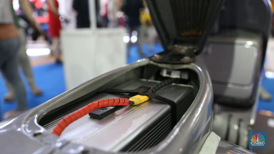 Pengunjung melihat motor lawas yang di konversi menjadi motor listrik pada booth PLN dalam ajang pameran otomotif Indonesia International Motor Show (IIMS) 2023 pada Sabtu (18/2/2023). (CNBC Indonesia/Tias Budiarto)