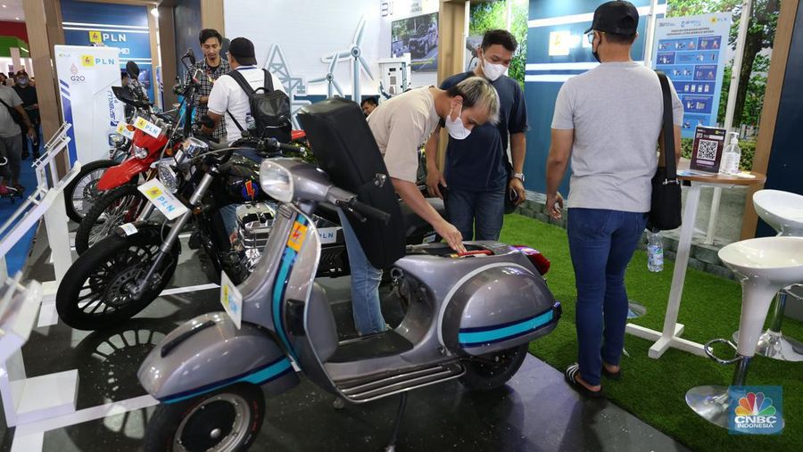 Pengunjung melihat motor lawas yang di konversi menjadi motor listrik pada booth PLN dalam ajang pameran otomotif Indonesia International Motor Show (IIMS) 2023 pada Sabtu (18/2/2023). (CNBC Indonesia/Tias Budiarto)