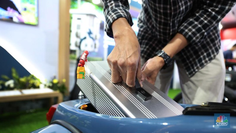 Pengunjung melihat motor lawas yang di konversi menjadi motor listrik pada booth PLN dalam ajang pameran otomotif Indonesia International Motor Show (IIMS) 2023 pada Sabtu (18/2/2023). (CNBC Indonesia/Tias Budiarto)
