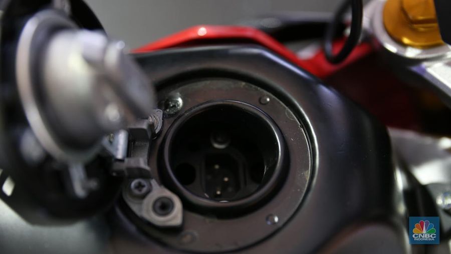 Pengunjung melihat motor lawas yang di konversi menjadi motor listrik pada booth PLN dalam ajang pameran otomotif Indonesia International Motor Show (IIMS) 2023 pada Sabtu (18/2/2023). (CNBC Indonesia/Tias Budiarto)