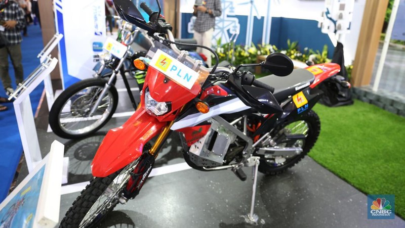 Pengunjung melihat motor lawas yang di konversi menjadi motor listrik pada booth PLN dalam ajang pameran otomotif Indonesia International Motor Show (IIMS) 2023 pada Sabtu (18/2/2023). (CNBC Indonesia/Tias Budiarto)