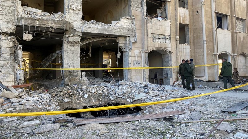 Police officers stand near a damaged building at the site of a rocket attack, in central Damascus' Kafr Sousa neighborhood, Syria, February 19, 2023. REUTERS/Firas Makdessi