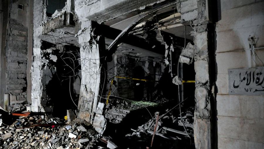 Police officers stand near a damaged building at the site of a rocket attack, in central Damascus' Kafr Sousa neighborhood, Syria, February 19, 2023. REUTERS/Firas Makdessi
