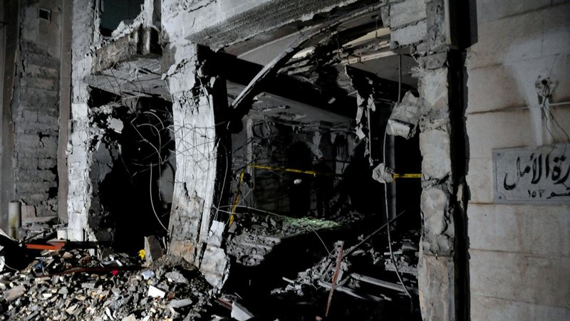 Police officers stand near a damaged building at the site of a rocket attack, in central Damascus' Kafr Sousa neighborhood, Syria, February 19, 2023. REUTERS/Firas Makdessi