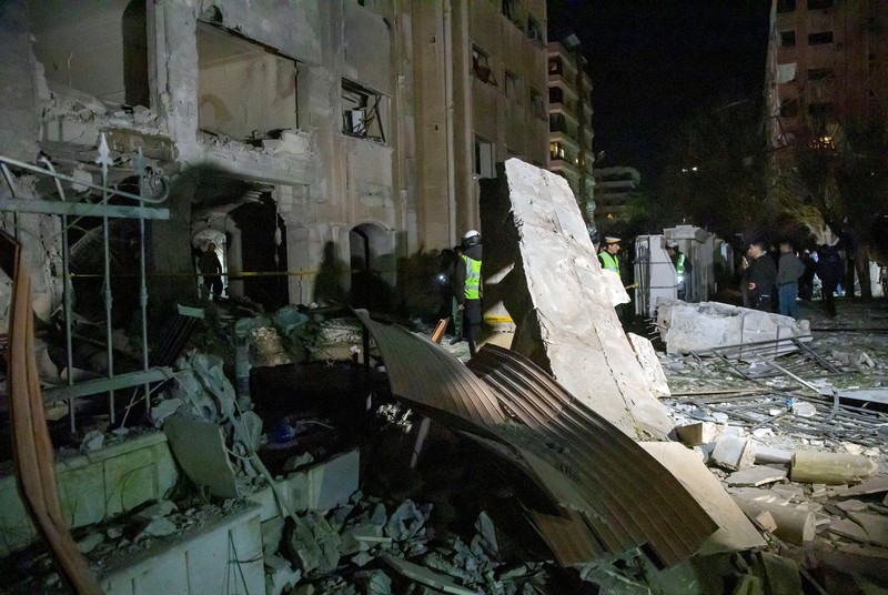 SYRIA-SECURITY/ISRAEL-ROCKET Police officers stand near a damaged building at the site of a rocket attack, in central Damascus' Kafr Sousa neighborhood, Syria, February 19, 2023. REUTERS/Firas Makdessi