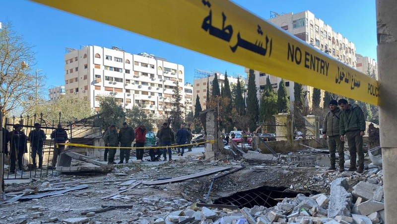 Police officers stand near a damaged building at the site of a rocket attack, in central Damascus' Kafr Sousa neighborhood, Syria, February 19, 2023. REUTERS/Firas Makdessi