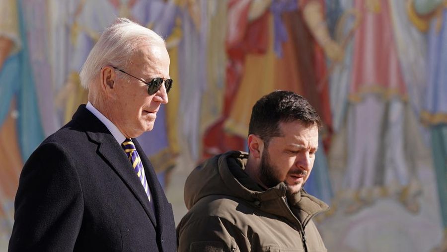 Presiden AS Joe Biden (kiri) berjalan di samping Presiden Ukraina Volodymyr Zelensky (kanan) saat ia tiba untuk berkunjung di Kyiv pada 20 Februari 2023. - Presiden AS Joe Biden melakukan perjalanan kejutan ke Kyiv pada 20 Februari 2023, menjelang peringatan pertama invasi Rusia ke Ukraina, wartawan AFP melihatnya. Biden bertemu dengan Presiden Ukraina Volodymyr Zelensky di ibu kota Ukraina pada kunjungan pertamanya ke negara itu sejak awal konflik. (Photo by Dimitar DILKOFF / AFP) (Photo by DIMITAR DILKOFF/AFP via Getty Images)