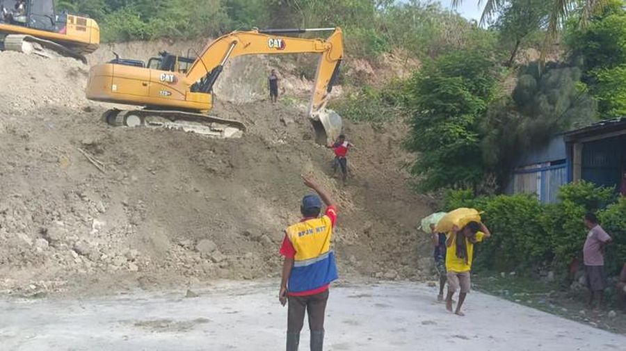 Sejumlah alat berat dikerahkan untuk membersihkan material longsor di ruas Jalan Timor Raya di Kelurahan Takari, Kecamatan Takari, Kabupaten Kupang, Nusa Tenggara Timur (NTT), Minggu (19/2/2023). (Dok. detikBali/ Yufen Ernesto)
