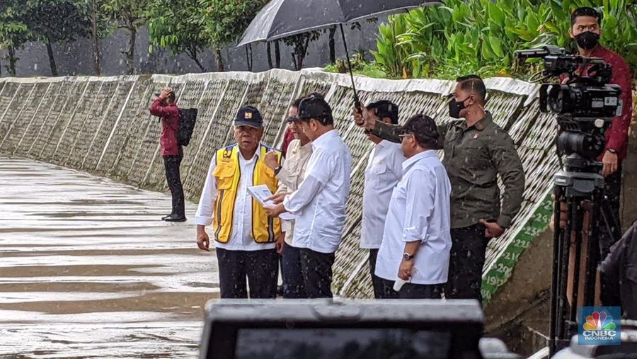 Di tengah hujan lebat Presiden Joko Widodo melakukan peninjauan titik normalisasi kali Ciliwung, yang berada di Jalan Inspeksi Ciliwung, Jakarta Selatan, pada Selasa (21/2/2023). (CNBC Indonesia/Emir Yanwardhana)