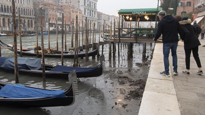 Italia kini tengah dilanda kekeringan hebat. Akibatnya, kanal-kanal di Venesia terlihat mengering dan menyebabkan taksi air, gondola dan transportasi air lainnya, tak bisa beraktivitas di beberapa kanal. (AP/Luigi Costantini)