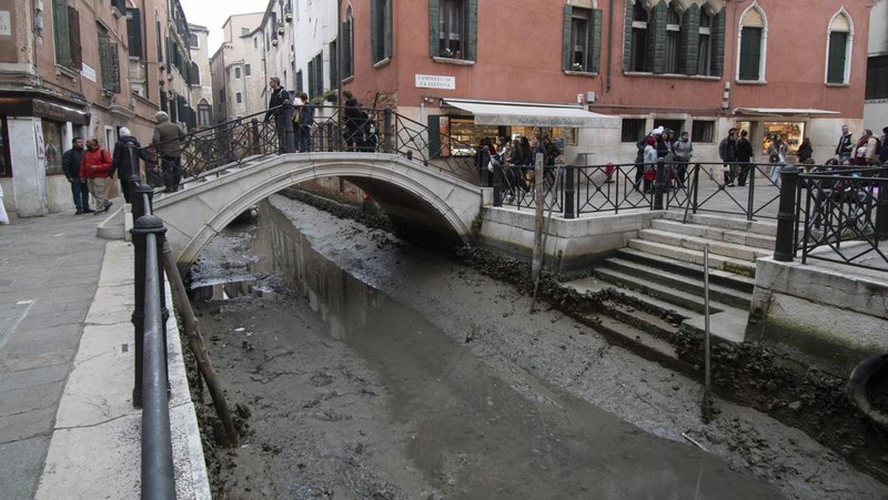 Italia kini tengah dilanda kekeringan hebat. Akibatnya, kanal-kanal di Venesia terlihat mengering dan menyebabkan taksi air, gondola dan transportasi air lainnya, tak bisa beraktivitas di beberapa kanal. (AP/Luigi Costantini)