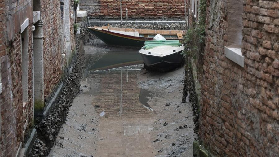 Italia kini tengah dilanda kekeringan hebat. Akibatnya, kanal-kanal di Venesia terlihat mengering dan menyebabkan taksi air, gondola dan transportasi air lainnya, tak bisa beraktivitas di beberapa kanal. (AP/Luigi Costantini)