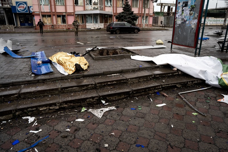 Pekerja darurat merawat korban setelah serangan roket BM-21 meledakkan halte bus di Kherson, Ukraina pada 21 Februari 2023. (Vincenzo Circosta/Anadolu Agency via Getty Images)