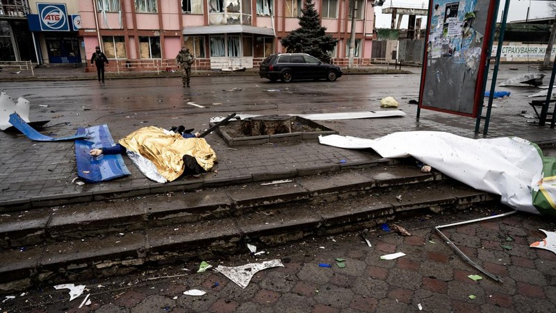 Pekerja darurat merawat korban setelah serangan roket BM-21 meledakkan halte bus di Kherson, Ukraina pada 21 Februari 2023. (Vincenzo Circosta/Anadolu Agency via Getty Images)