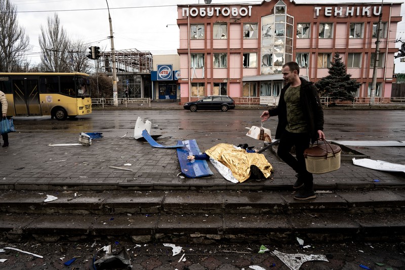 Pekerja darurat merawat korban setelah serangan roket BM-21 meledakkan halte bus di Kherson, Ukraina pada 21 Februari 2023. (Vincenzo Circosta/Anadolu Agency via Getty Images)