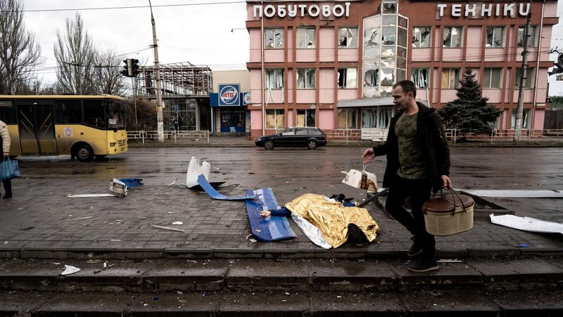 Pekerja darurat merawat korban setelah serangan roket BM-21 meledakkan halte bus di Kherson, Ukraina pada 21 Februari 2023. (Vincenzo Circosta/Anadolu Agency via Getty Images)