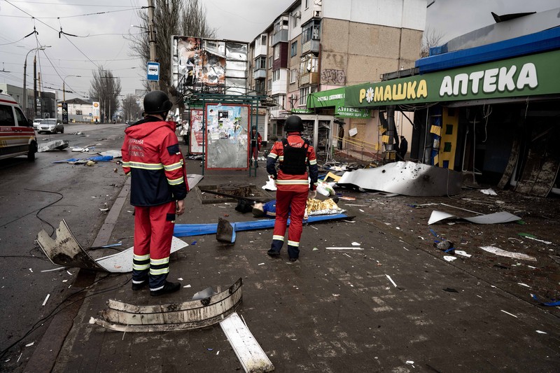 Pekerja darurat merawat korban setelah serangan roket BM-21 meledakkan halte bus di Kherson, Ukraina pada 21 Februari 2023. (Vincenzo Circosta/Anadolu Agency via Getty Images)