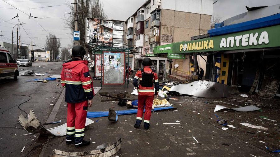 Pekerja darurat merawat korban setelah serangan roket BM-21 meledakkan halte bus di Kherson, Ukraina pada 21 Februari 2023. (Vincenzo Circosta/Anadolu Agency via Getty Images)