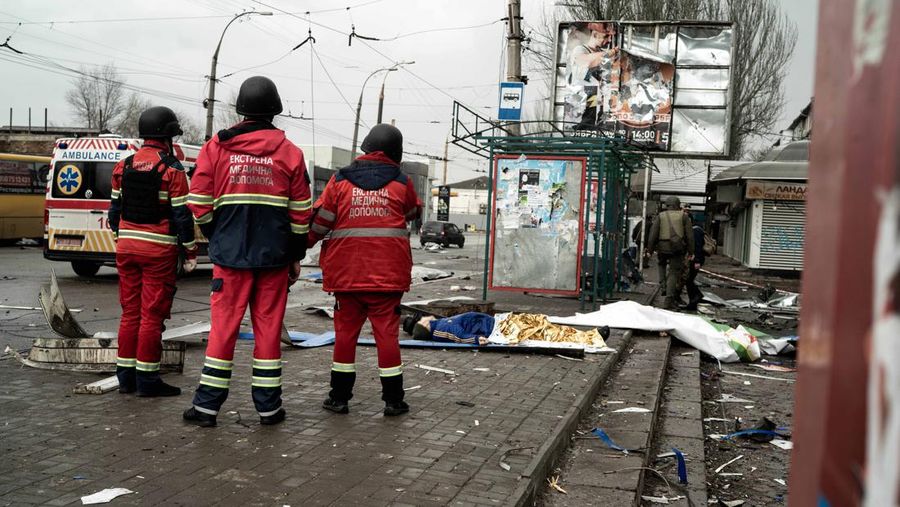 Pekerja darurat merawat korban setelah serangan roket BM-21 meledakkan halte bus di Kherson, Ukraina pada 21 Februari 2023. (Vincenzo Circosta/Anadolu Agency via Getty Images)