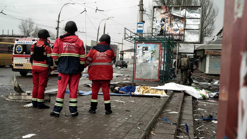 Pekerja darurat merawat korban setelah serangan roket BM-21 meledakkan halte bus di Kherson, Ukraina pada 21 Februari 2023. (Vincenzo Circosta/Anadolu Agency via Getty Images)