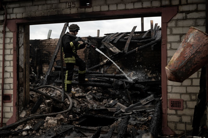 Pekerja darurat merawat korban setelah serangan roket BM-21 meledakkan halte bus di Kherson, Ukraina pada 21 Februari 2023. (Vincenzo Circosta/Anadolu Agency via Getty Images)
