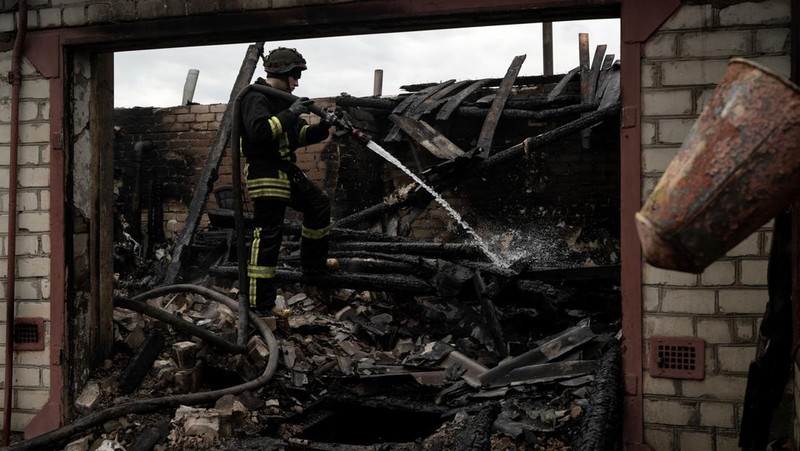 Pekerja darurat merawat korban setelah serangan roket BM-21 meledakkan halte bus di Kherson, Ukraina pada 21 Februari 2023. (Vincenzo Circosta/Anadolu Agency via Getty Images)