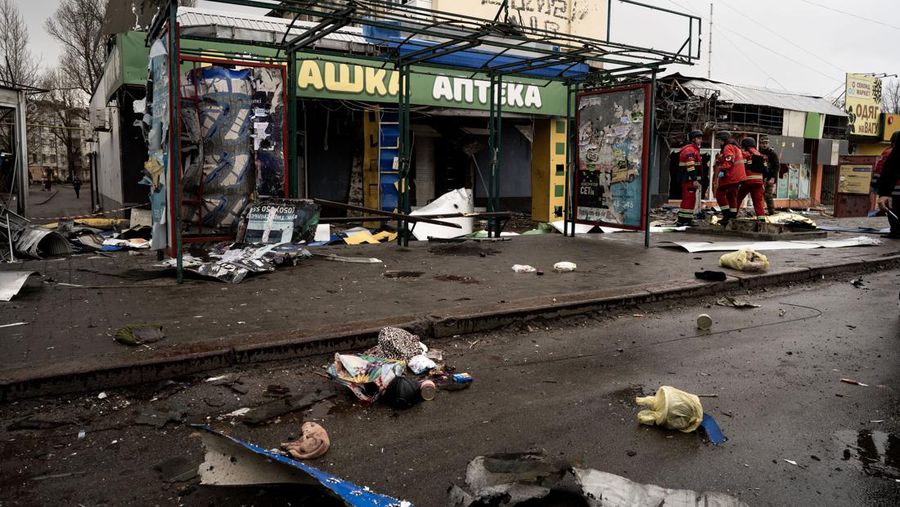 Pekerja darurat merawat korban setelah serangan roket BM-21 meledakkan halte bus di Kherson, Ukraina pada 21 Februari 2023. (Vincenzo Circosta/Anadolu Agency via Getty Images)