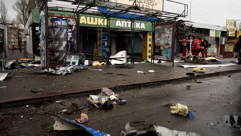 Pekerja darurat merawat korban setelah serangan roket BM-21 meledakkan halte bus di Kherson, Ukraina pada 21 Februari 2023. (Vincenzo Circosta/Anadolu Agency via Getty Images)