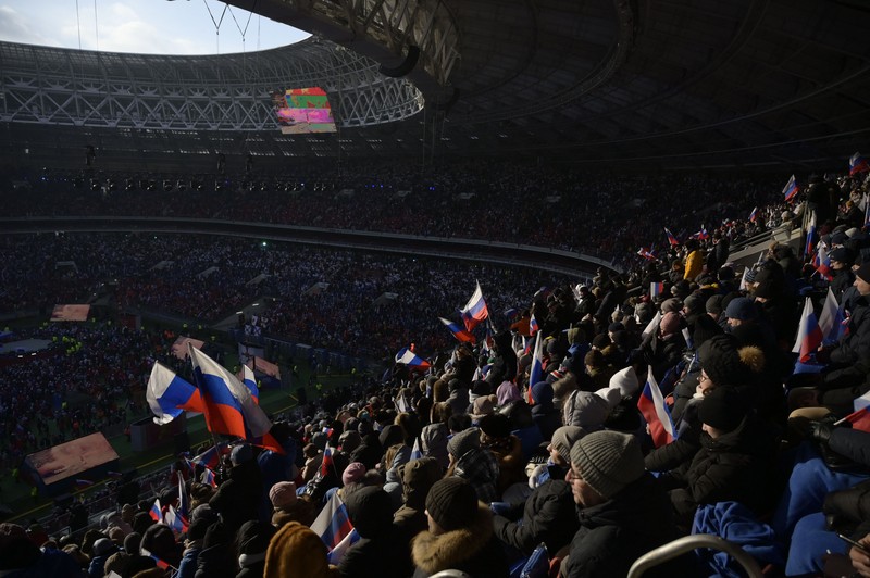 Orang-orang berkumpul di dekat monumen pendiri Uni Soviet Vladimir Lenin saat mereka tiba untuk konser patriotik yang didedikasikan untuk Hari Pembela Tanah Air yang akan datang di stadion Luzhniki di Moskow pada 22 Februari 2023. (AFP via Getty Images/NATALIA KOLESNIKOVA)