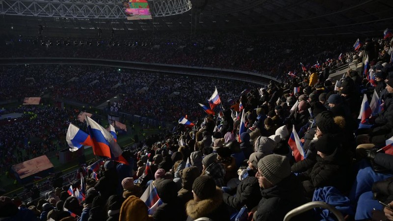 Orang-orang berkumpul di dekat monumen pendiri Uni Soviet Vladimir Lenin saat mereka tiba untuk konser patriotik yang didedikasikan untuk Hari Pembela Tanah Air yang akan datang di stadion Luzhniki di Moskow pada 22 Februari 2023. (AFP via Getty Images/NATALIA KOLESNIKOVA)