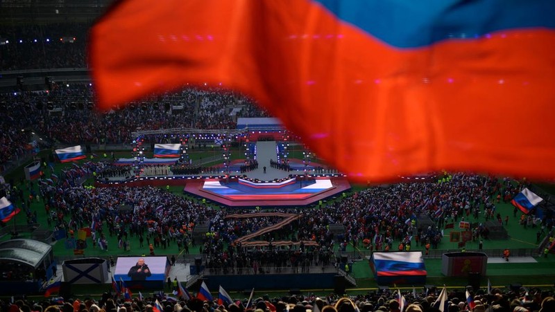 Orang-orang berkumpul di dekat monumen pendiri Uni Soviet Vladimir Lenin saat mereka tiba untuk konser patriotik yang didedikasikan untuk Hari Pembela Tanah Air yang akan datang di stadion Luzhniki di Moskow pada 22 Februari 2023. (AFP via Getty Images/NATALIA KOLESNIKOVA)