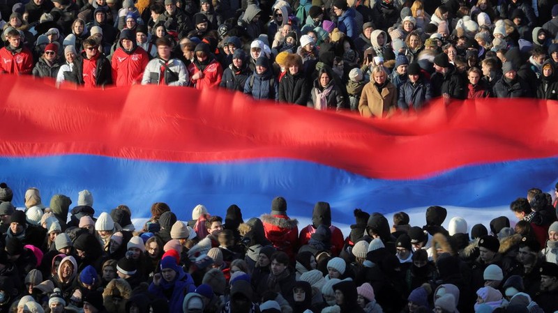 Orang-orang berkumpul di dekat monumen pendiri Uni Soviet Vladimir Lenin saat mereka tiba untuk konser patriotik yang didedikasikan untuk Hari Pembela Tanah Air yang akan datang di stadion Luzhniki di Moskow pada 22 Februari 2023. (AFP via Getty Images/NATALIA KOLESNIKOVA)