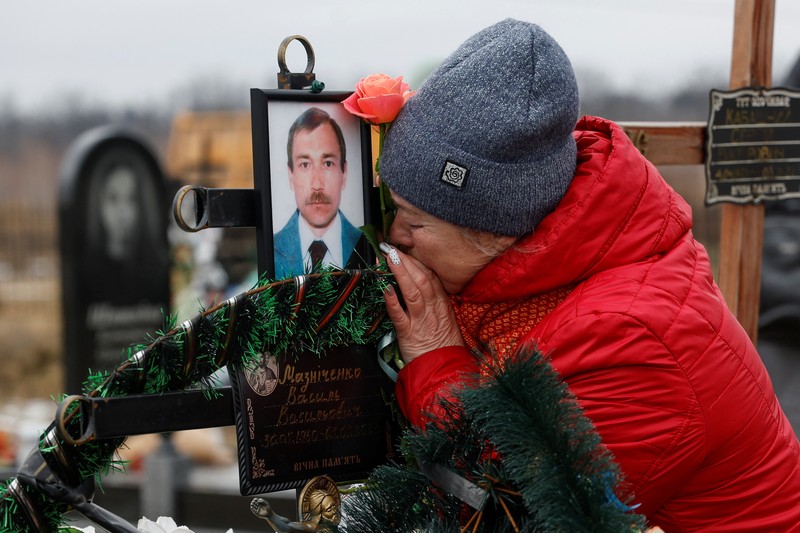 Istri Natalia bereaksi di makam Vasyl Maznichenko, penduduk lokal yang dibunuh oleh tentara Rusia selama pendudukan kota Bucha, pada hari peringatan pertama serangan Rusia di Ukraina, di pemakaman kota, di luar Kyiv, Ukraina 24 Februari 2023. Istri Natalia bereaksi di makam Vasyl Maznichenko, penduduk lokal yang dibunuh oleh tentara Rusia selama pendudukan kota Bucha, pada hari peringatan pertama serangan Rusia di Ukraina, di pemakaman kota, di luar Kyiv, Ukraina 24 Februari 2023. (REUTERS/Valentyn Ogirenko)