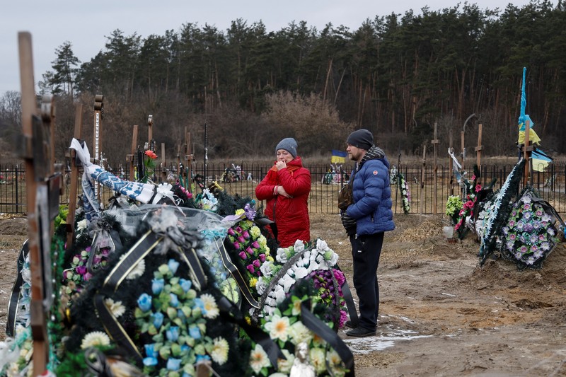 Istri Natalia bereaksi di makam Vasyl Maznichenko, penduduk lokal yang dibunuh oleh tentara Rusia selama pendudukan kota Bucha, pada hari peringatan pertama serangan Rusia di Ukraina, di pemakaman kota, di luar Kyiv, Ukraina 24 Februari 2023. (REUTERS/Valentyn Ogirenko)