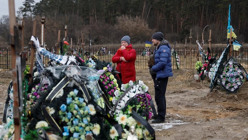 Istri Natalia bereaksi di makam Vasyl Maznichenko, penduduk lokal yang dibunuh oleh tentara Rusia selama pendudukan kota Bucha, pada hari peringatan pertama serangan Rusia di Ukraina, di pemakaman kota, di luar Kyiv, Ukraina 24 Februari 2023. (REUTERS/Valentyn Ogirenko)