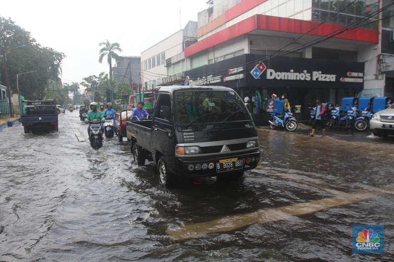 Pengendara melintasi genangan di Kawasan Green Garden, Kedoya, Jakarta Barat, Jumat (24/2/2023). Pengendara melintasi genangan di Kawasan Green Garden, Kedoya, Jakarta Barat, Jumat (24/2/2023). (CNBC Indonesia/ Muhammad Sabki)