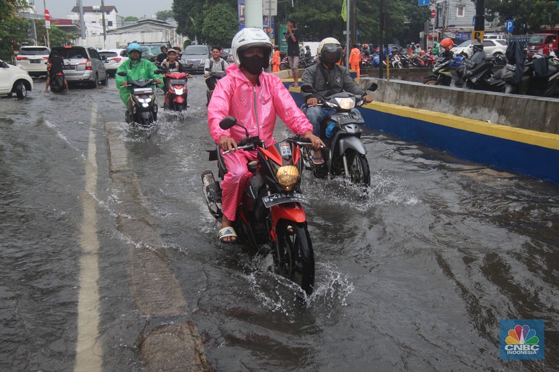 Pengendara melintasi genangan di Kawasan Green Garden, Kedoya, Jakarta Barat, Jumat (24/2/2023). Pengendara melintasi genangan di Kawasan Green Garden, Kedoya, Jakarta Barat, Jumat (24/2/2023). (CNBC Indonesia/ Muhammad Sabki)