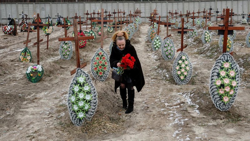 Istri Natalia bereaksi di makam Vasyl Maznichenko, penduduk lokal yang dibunuh oleh tentara Rusia selama pendudukan kota Bucha, pada hari peringatan pertama serangan Rusia di Ukraina, di pemakaman kota, di luar Kyiv, Ukraina 24 Februari 2023. (REUTERS/Valentyn Ogirenko)