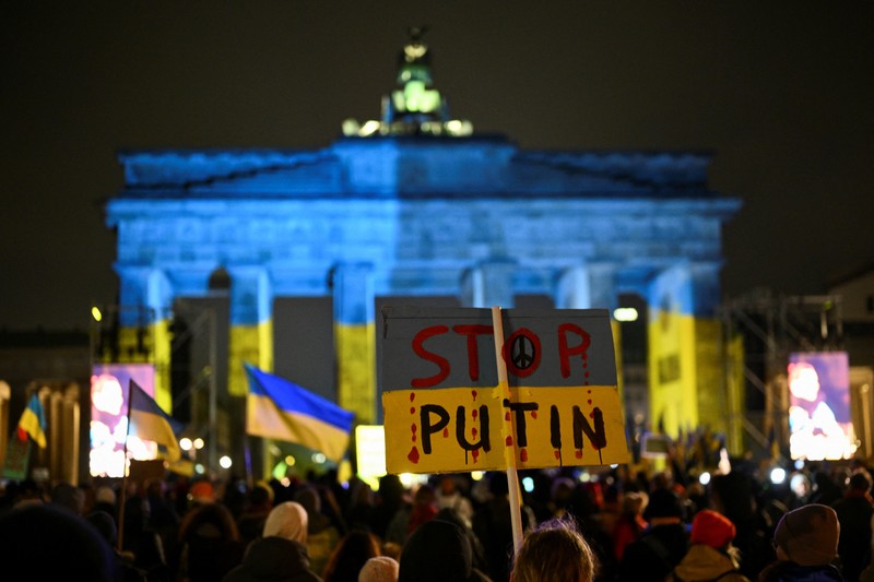 Seorang demonstran memegang poster protes warga Ukraina yang tinggal di Meksiko dan para demonstran untuk memperingati satu tahun invasi Rusia ke Ukraina, di monumen Malaikat Kemerdekaan di Mexico City, Meksiko 24 Februari 2023. (REUTERS/Henry Romero)