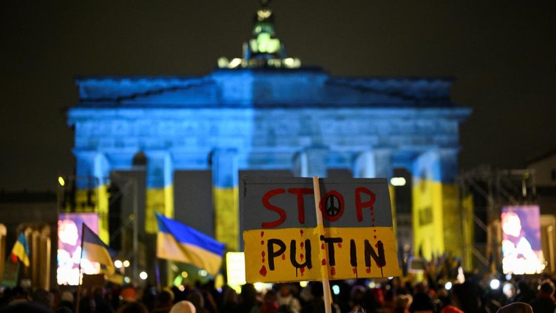 Seorang demonstran memegang poster protes warga Ukraina yang tinggal di Meksiko dan para demonstran untuk memperingati satu tahun invasi Rusia ke Ukraina, di monumen Malaikat Kemerdekaan di Mexico City, Meksiko 24 Februari 2023. (REUTERS/Henry Romero)
