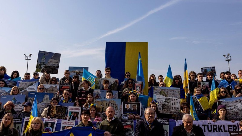Seorang demonstran memegang poster protes warga Ukraina yang tinggal di Meksiko dan para demonstran untuk memperingati satu tahun invasi Rusia ke Ukraina, di monumen Malaikat Kemerdekaan di Mexico City, Meksiko 24 Februari 2023. (REUTERS/Henry Romero)