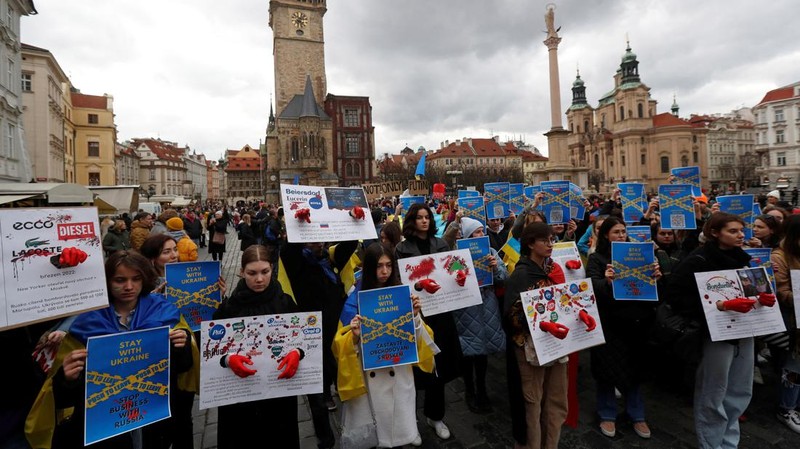 Seorang demonstran memegang poster protes warga Ukraina yang tinggal di Meksiko dan para demonstran untuk memperingati satu tahun invasi Rusia ke Ukraina, di monumen Malaikat Kemerdekaan di Mexico City, Meksiko 24 Februari 2023. (REUTERS/Henry Romero)